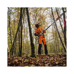 Professional using HTA 100 Cordless Pole Pruner for tree maintenance in a forest setting.