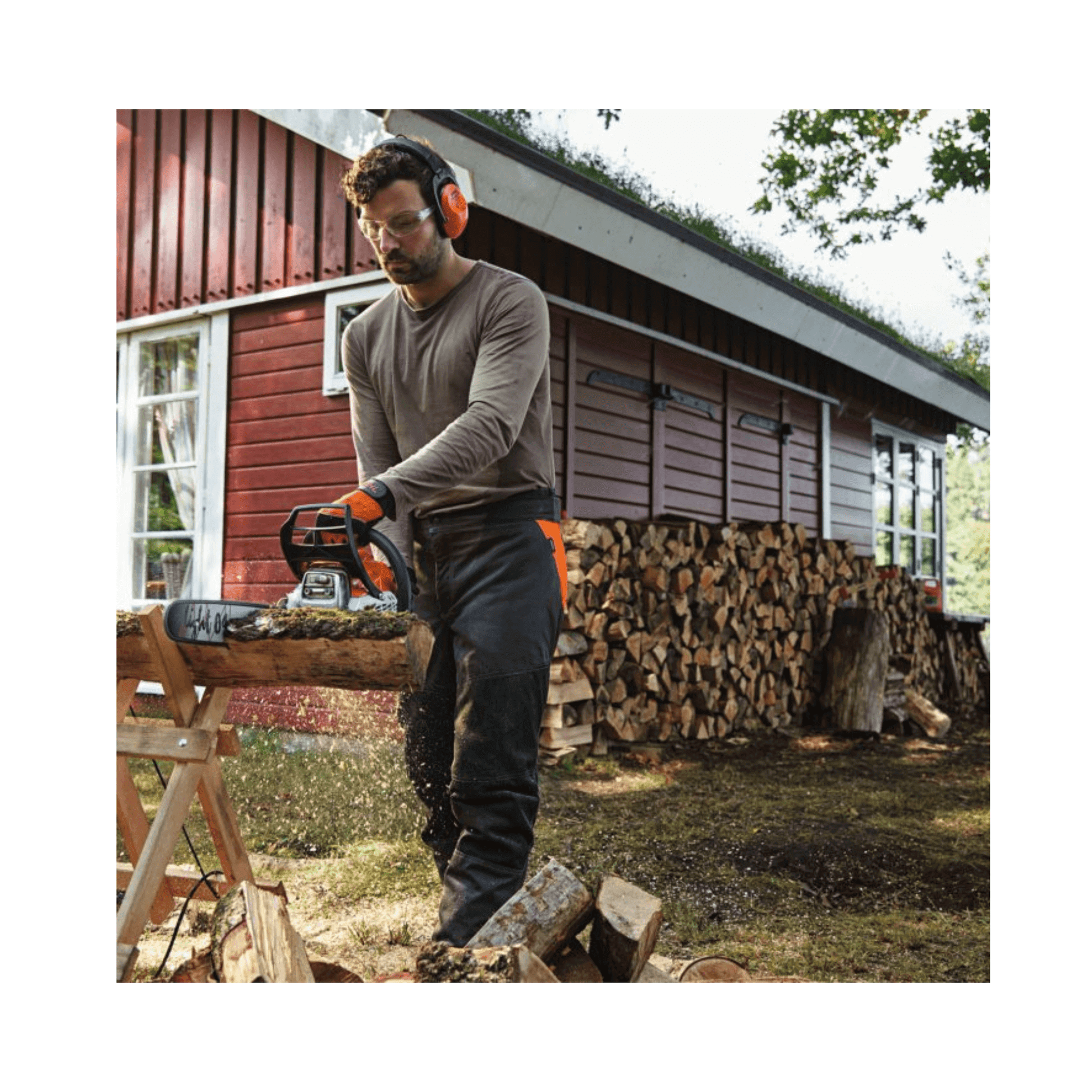 A man using a STIHL MS 212 C-BE petrol chainsaw to cut wood in a garden setting.