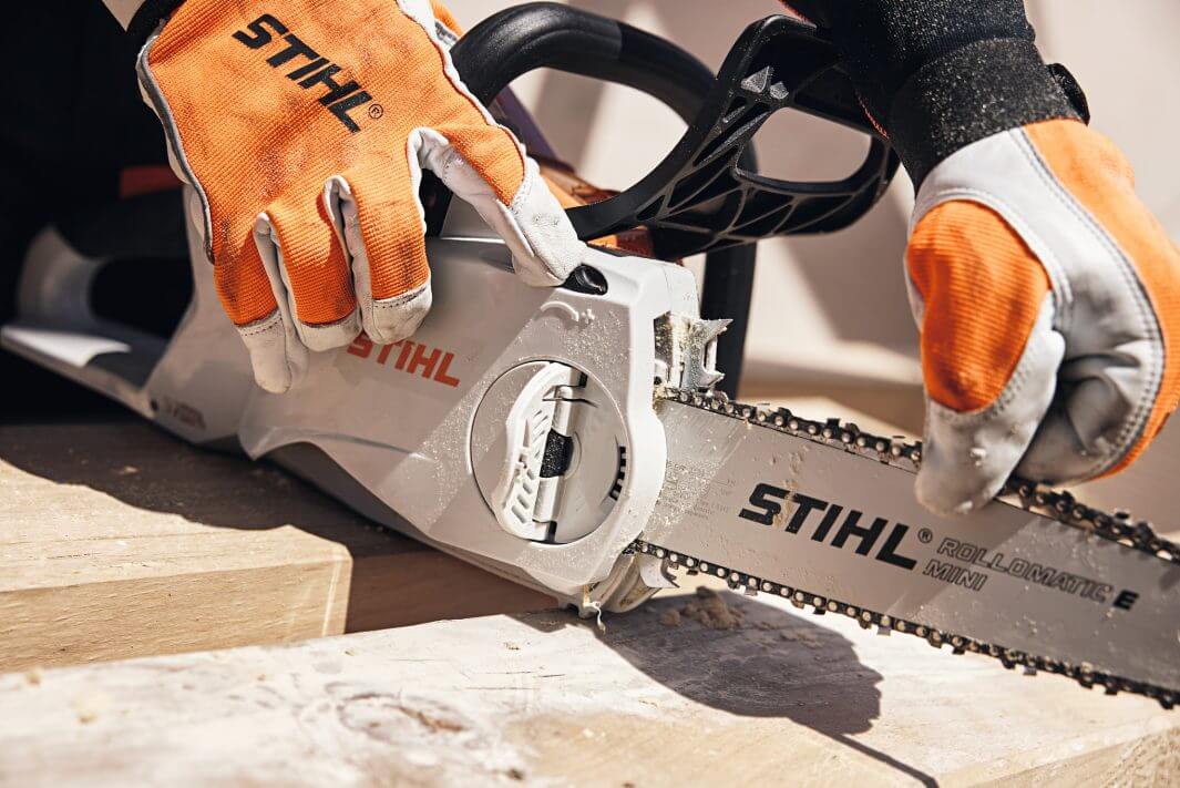 STIHL MSA 200 C-B cordless chainsaw being operated by a user with gloves, showcasing its features for woodworking.