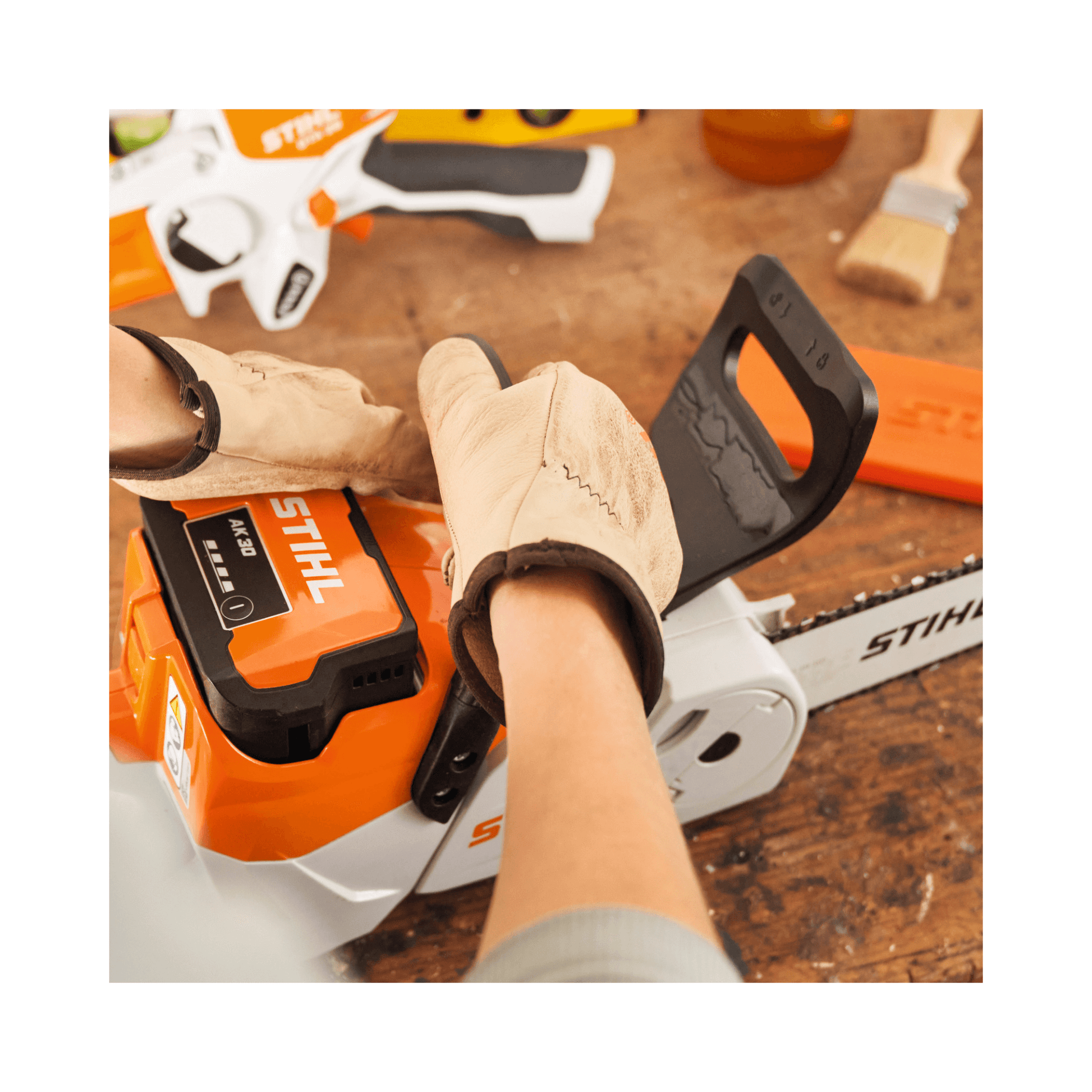 Hands wearing gloves adjusting the STIHL MSA 70 C-B cordless chainsaw, showcasing its lightweight design for tree surgeons.