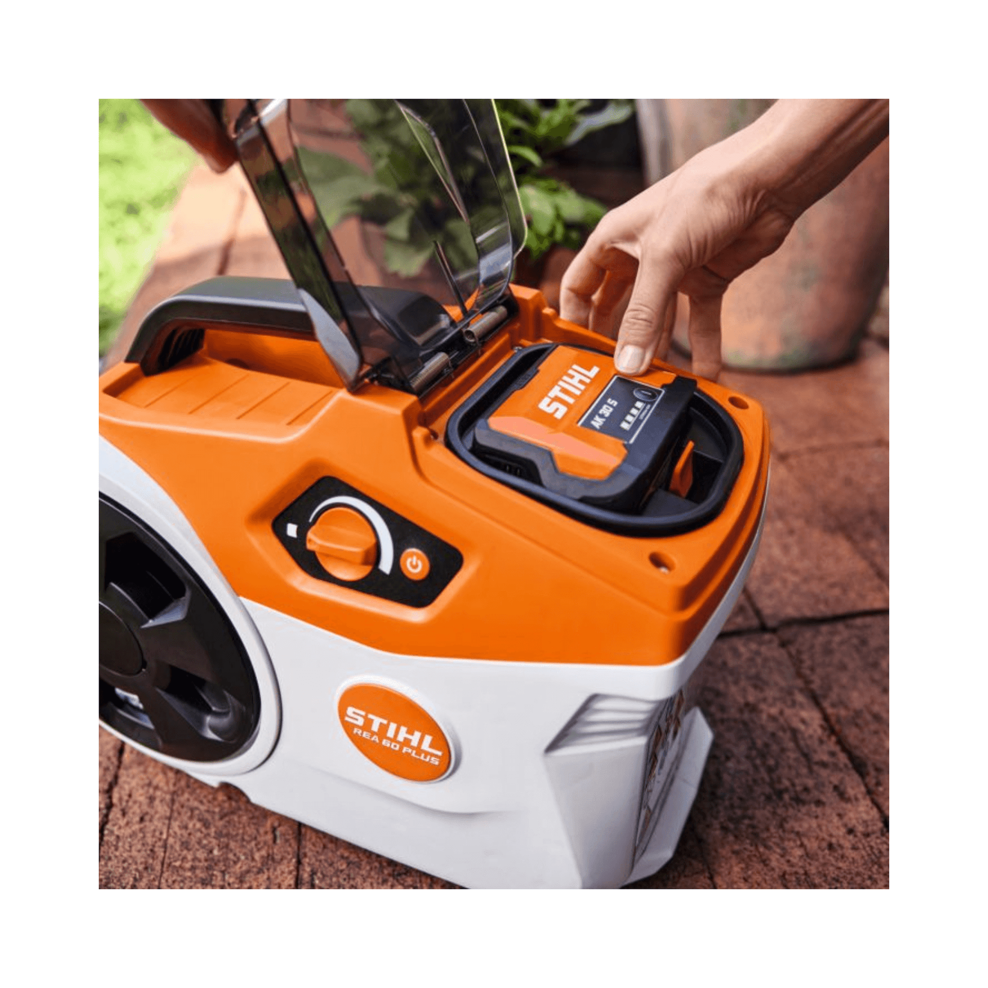 Close-up of STIHL REA 60 PLUS Cordless Pressure Washer with battery compartment open for easy access.