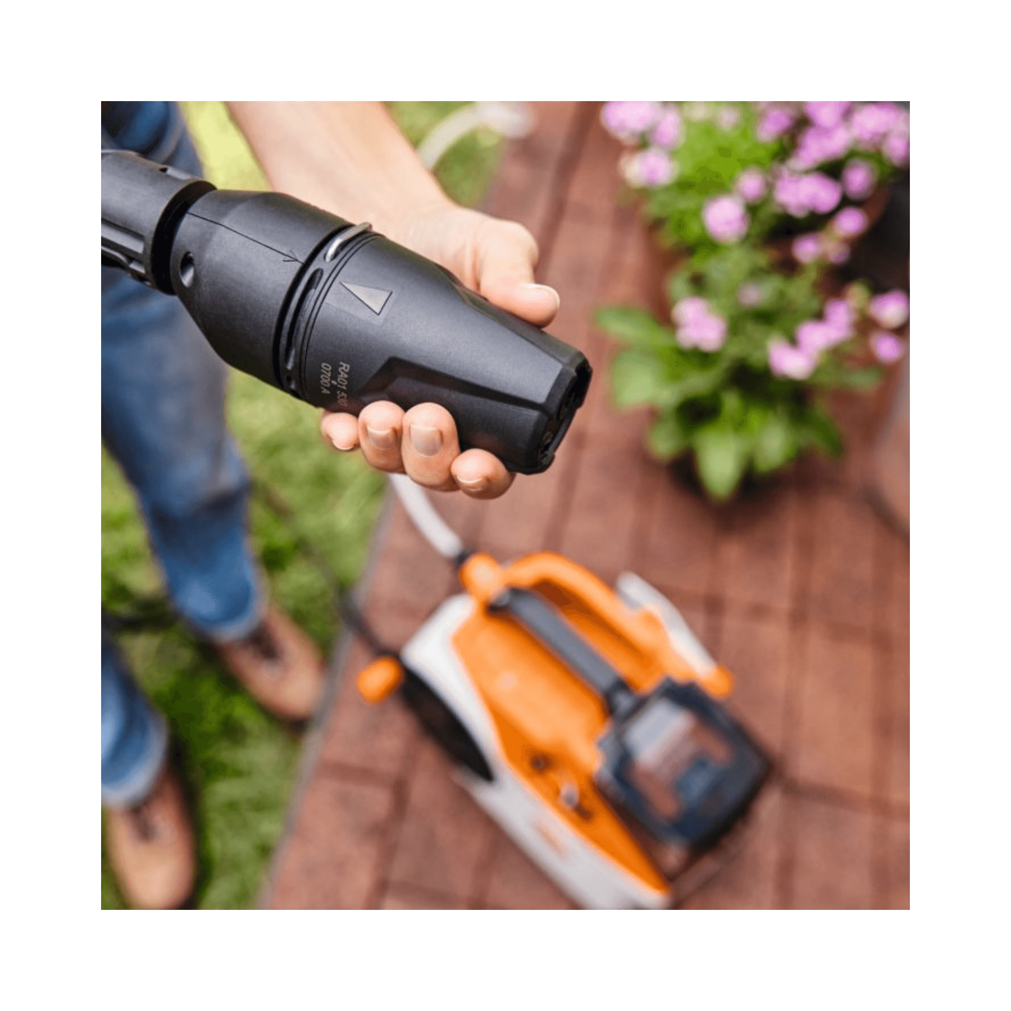User operating the STIHL REA 60 PLUS Cordless Pressure Washer with high-pressure nozzle.