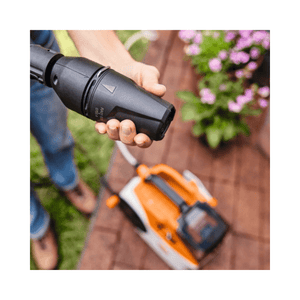 User operating the STIHL REA 60 PLUS Cordless Pressure Washer with high-pressure nozzle.