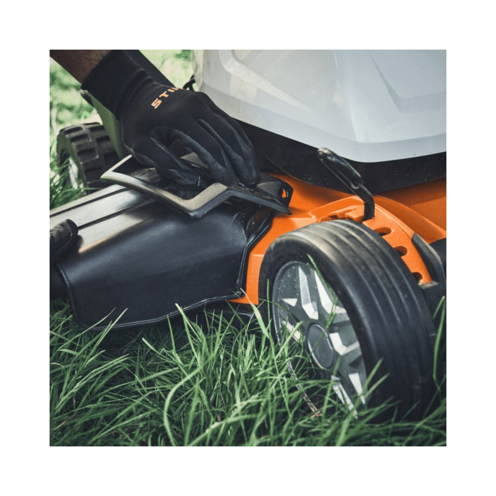 RMA 7 RV Professional Cordless Mulching Lawnmower being adjusted on grass by a user wearing gloves.