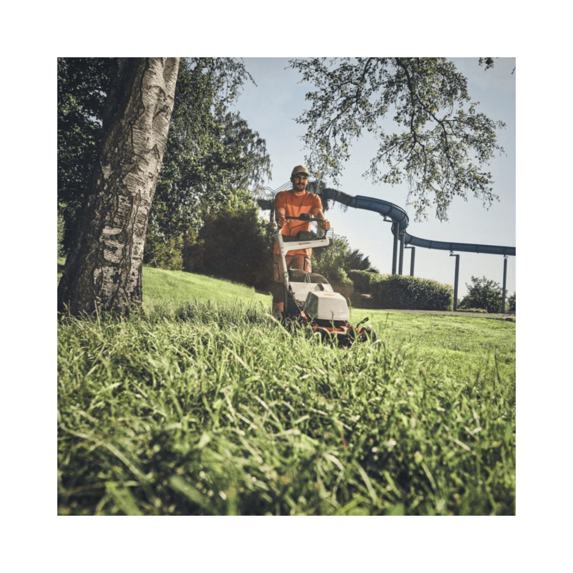 RMA 756V Professional Cordless Lawnmower in action, cutting grass in a landscaped area.