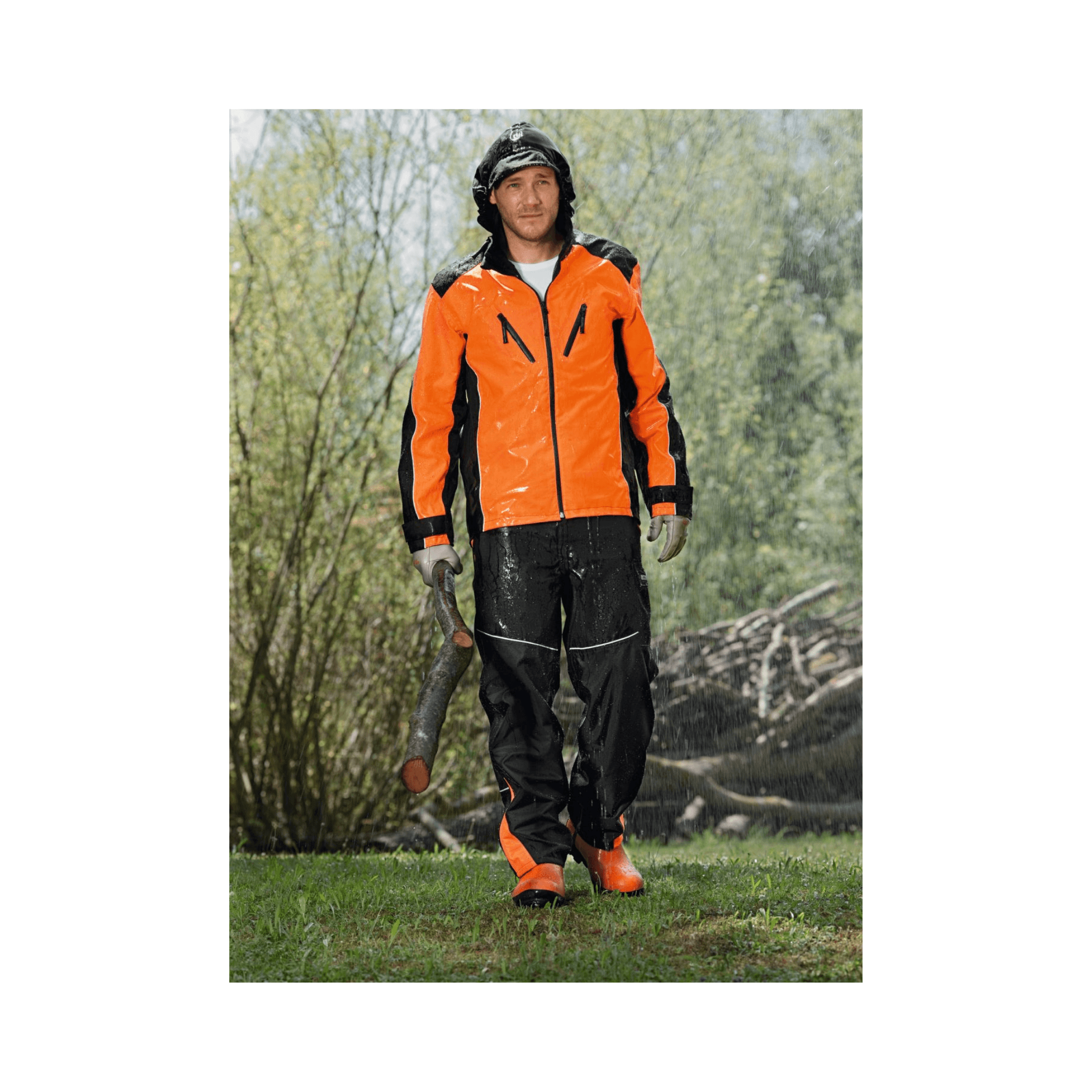 Man wearing Raintec Wet Weather Work Trousers and rain jacket in outdoor, wet conditions, ideal for work in forestry.