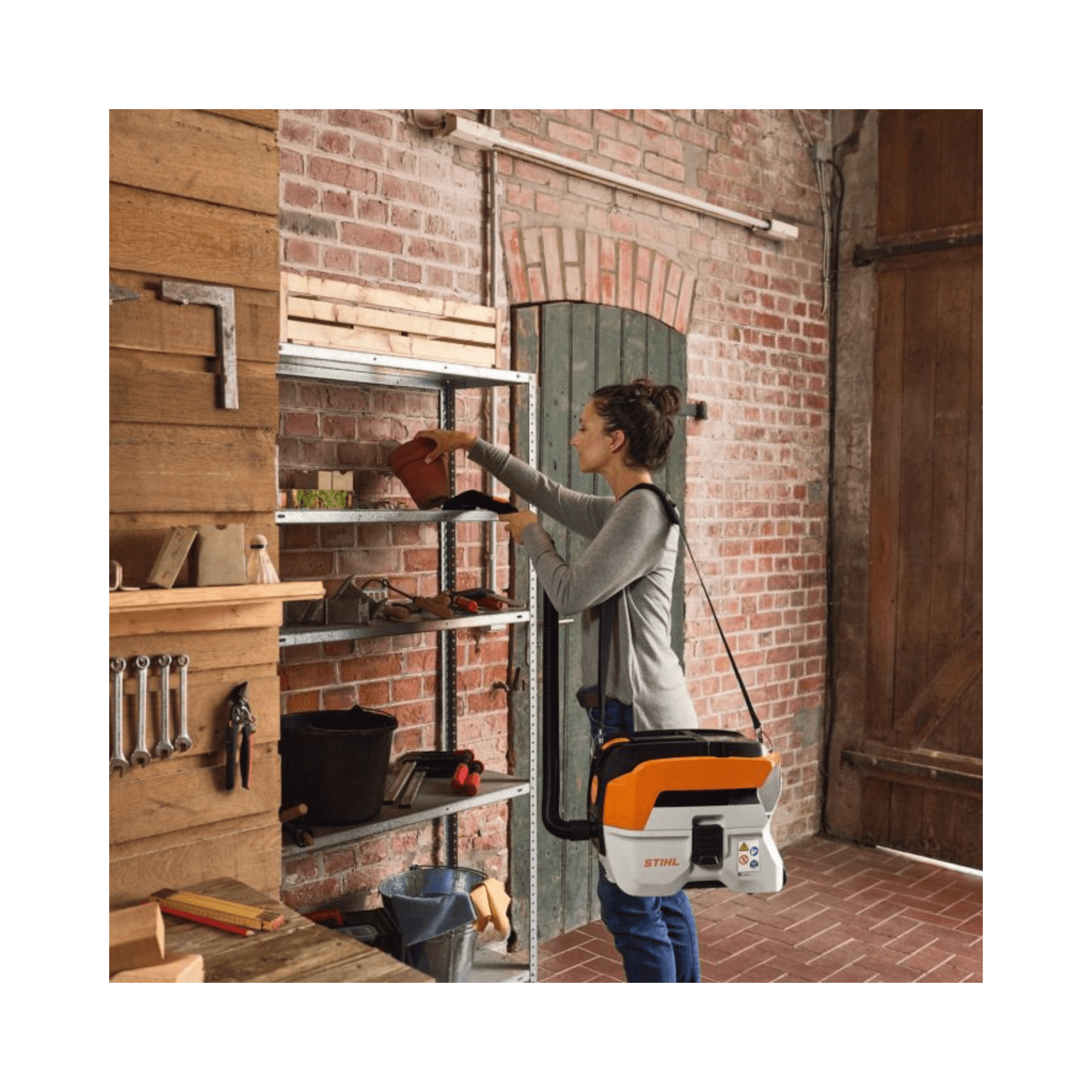STIHL SEA 50 Cordless Vacuum Cleaner in use for home cleaning tasks on shelving unit.