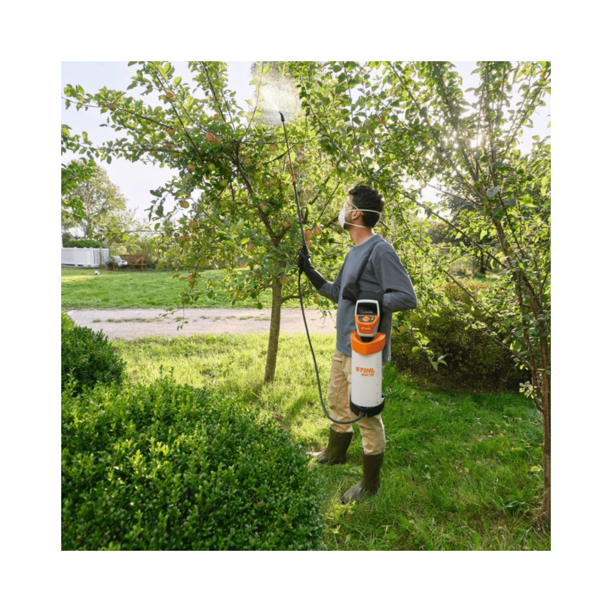Person using the SGA 30 Cordless Backpack Sprayer AS Battery Set for plant care in a garden.