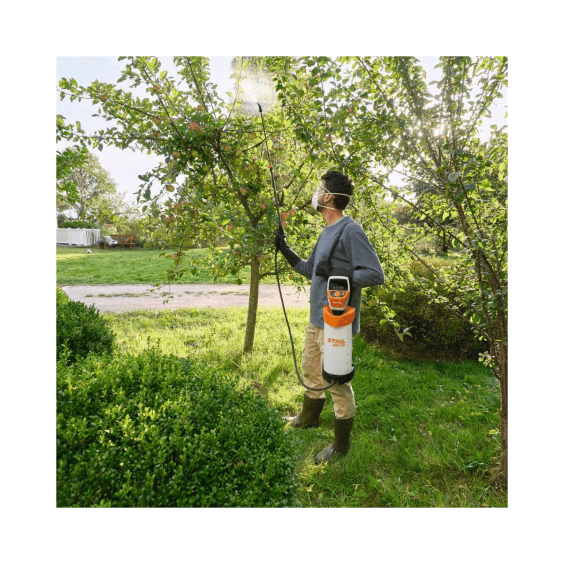 Person using the SGA 30 Cordless Backpack Sprayer AS Battery Set for plant care in a garden.