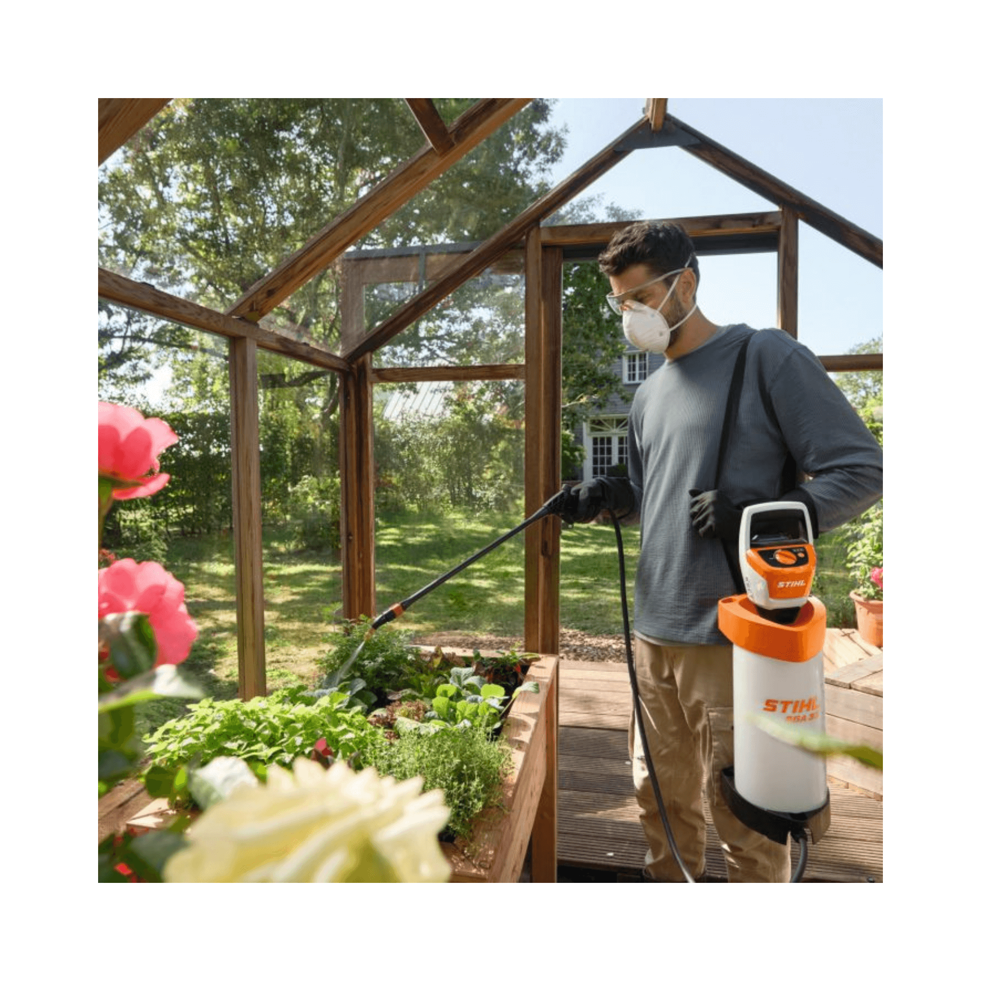 Man using SGA 30 Cordless Backpack Sprayer AS Battery Set in a greenhouse to spray plants.