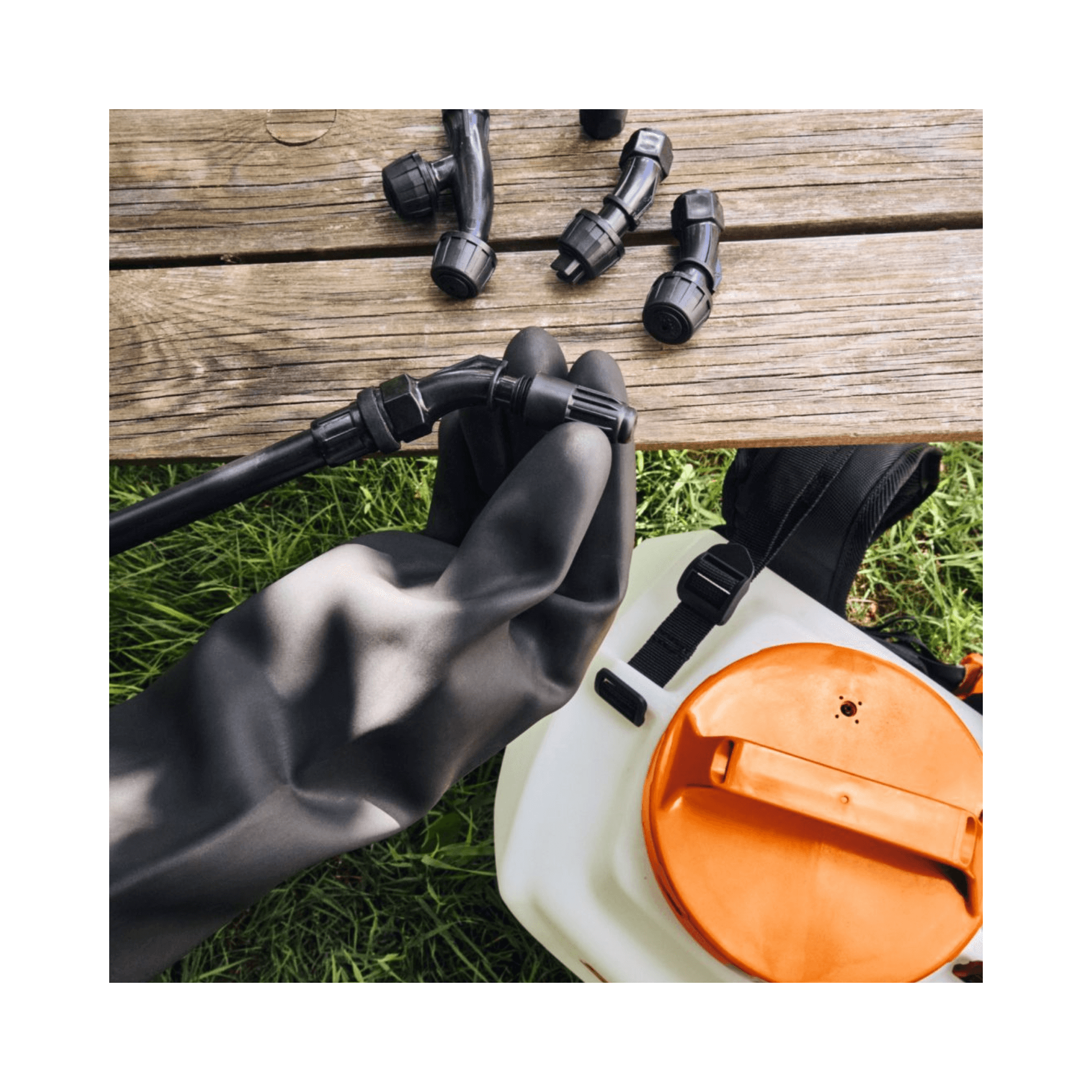 Parts and accessories for the SGA 60 Cordless Sprayer on a wooden surface.