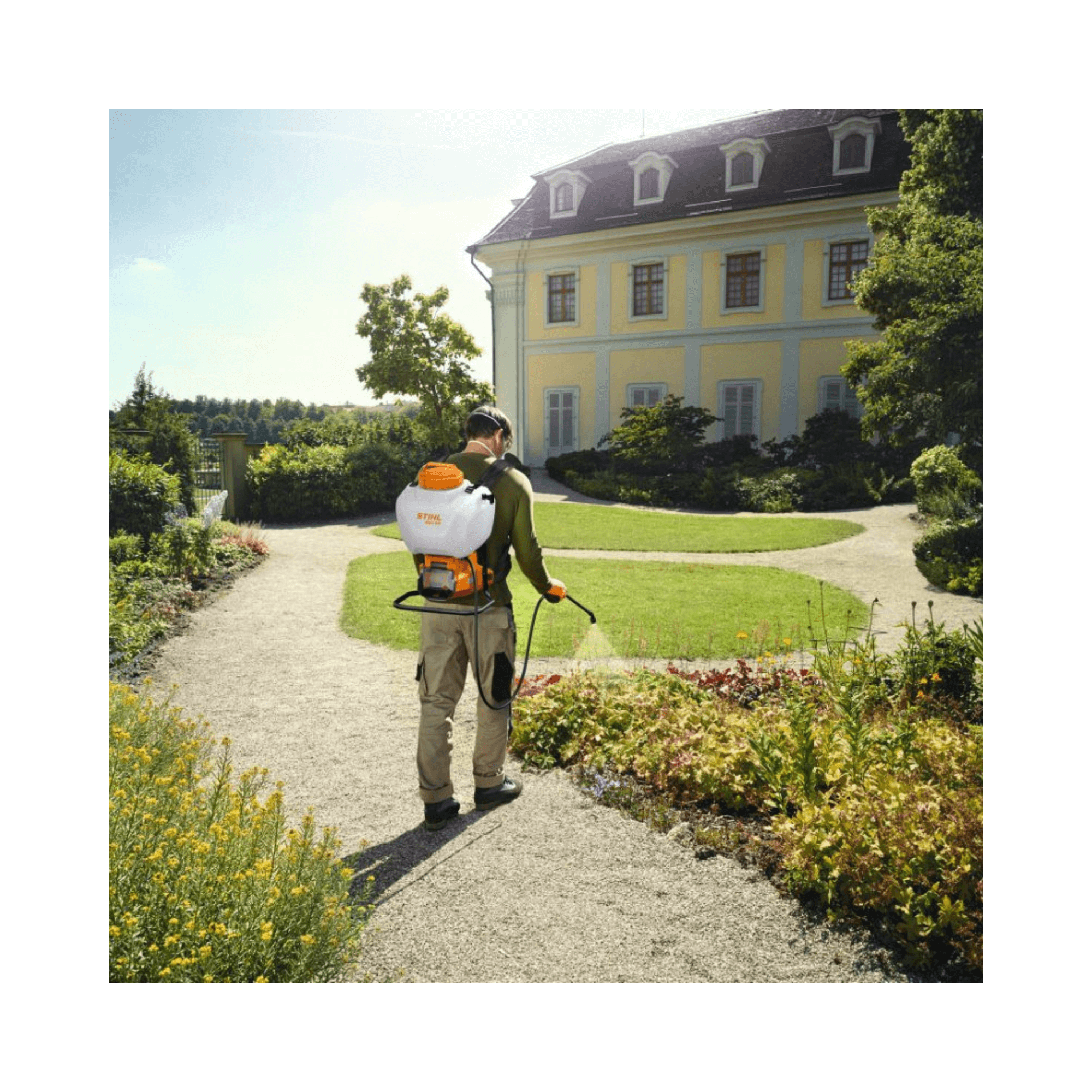 SGA 60 Cordless Sprayer user applying treatments in a lush garden setting.