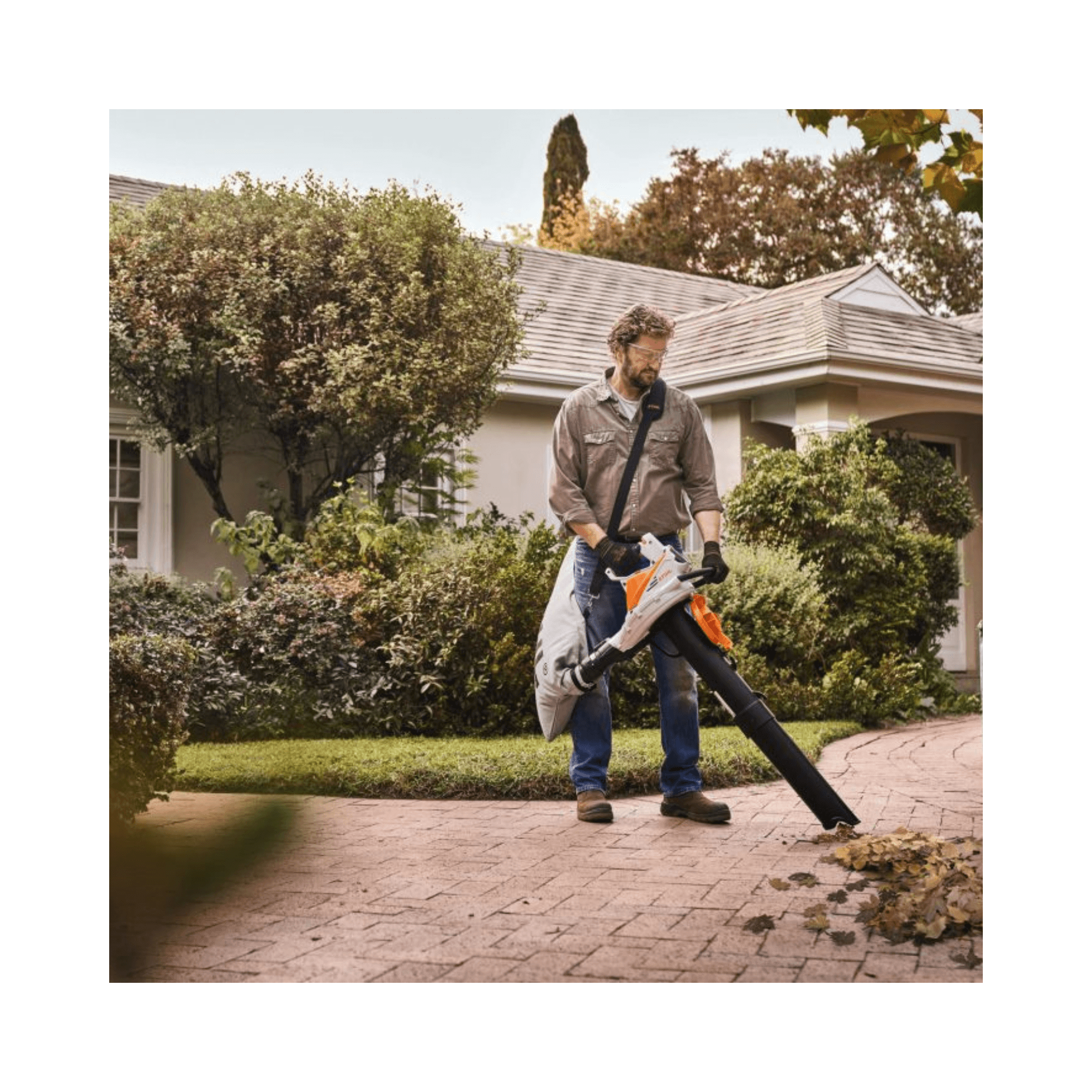 Person using SHA 56 Cordless Leaf Vacuum Shredder in a garden setting, showcasing its effectiveness for landscaping.