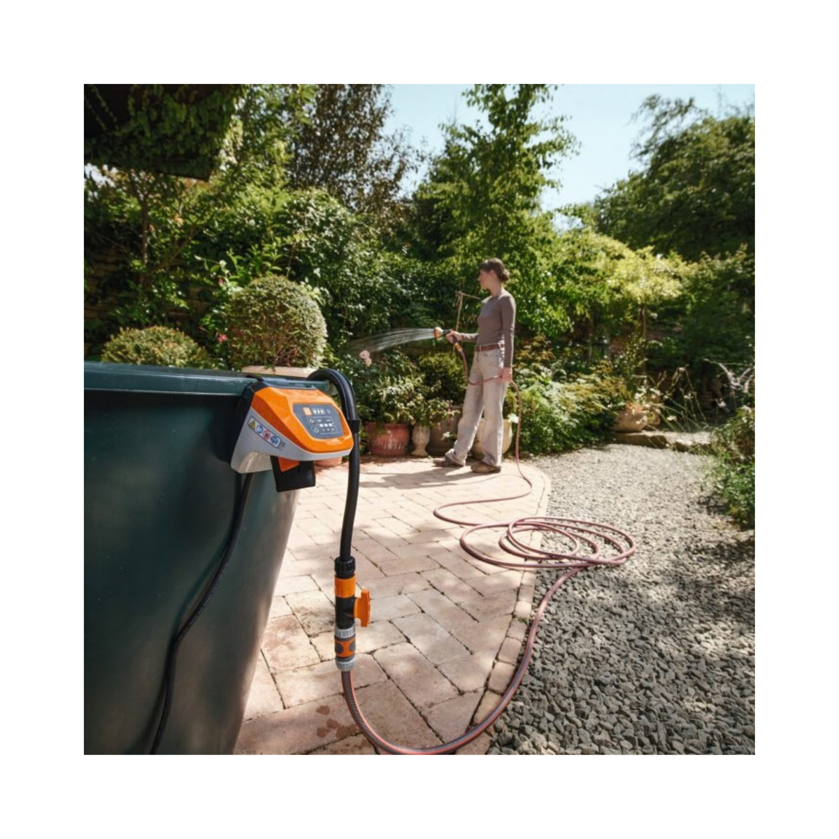 Person using TPA 20 Cordless Pump to water garden from a rainwater collection tank.