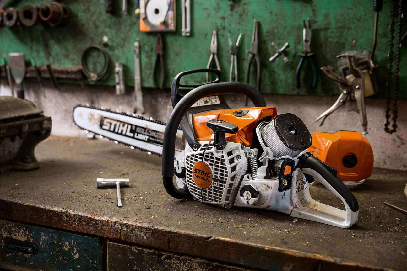 STIHL chainsaw resting on a workbench surrounded by tools, showcasing its robust design and functionality.