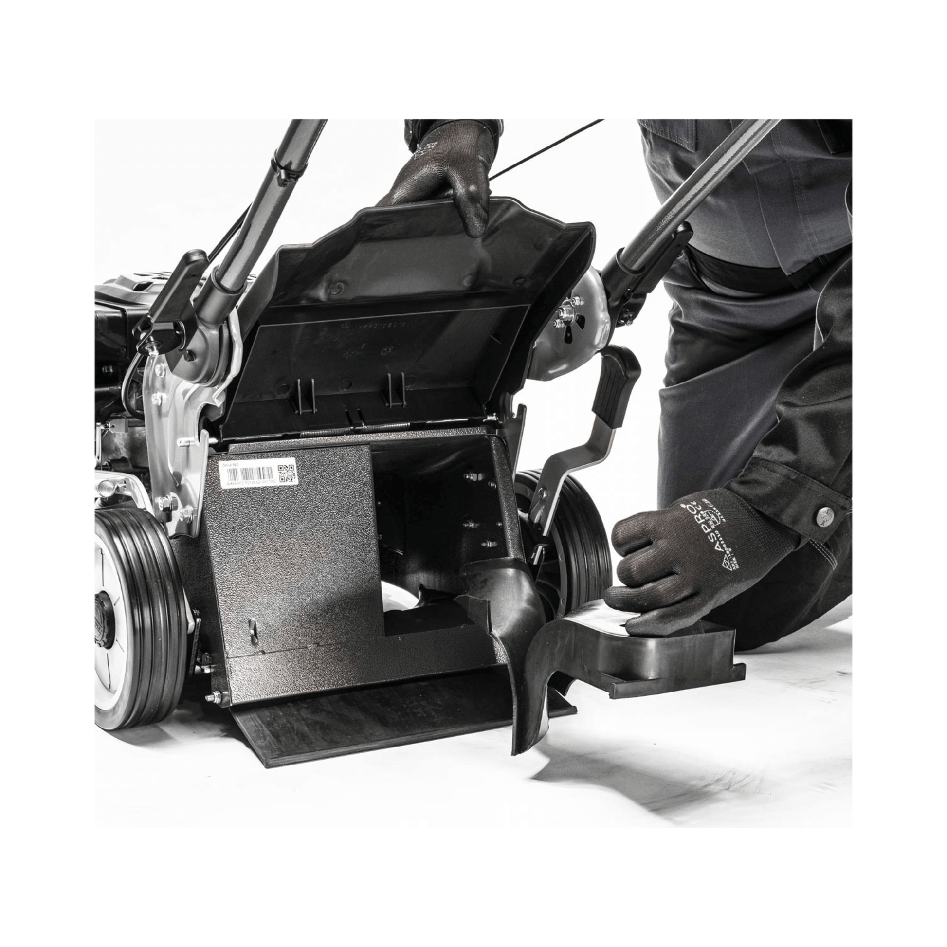 User adjusting the cutting height of the Virtue 46 SVP petrol lawn mower, showcasing its convenient features.