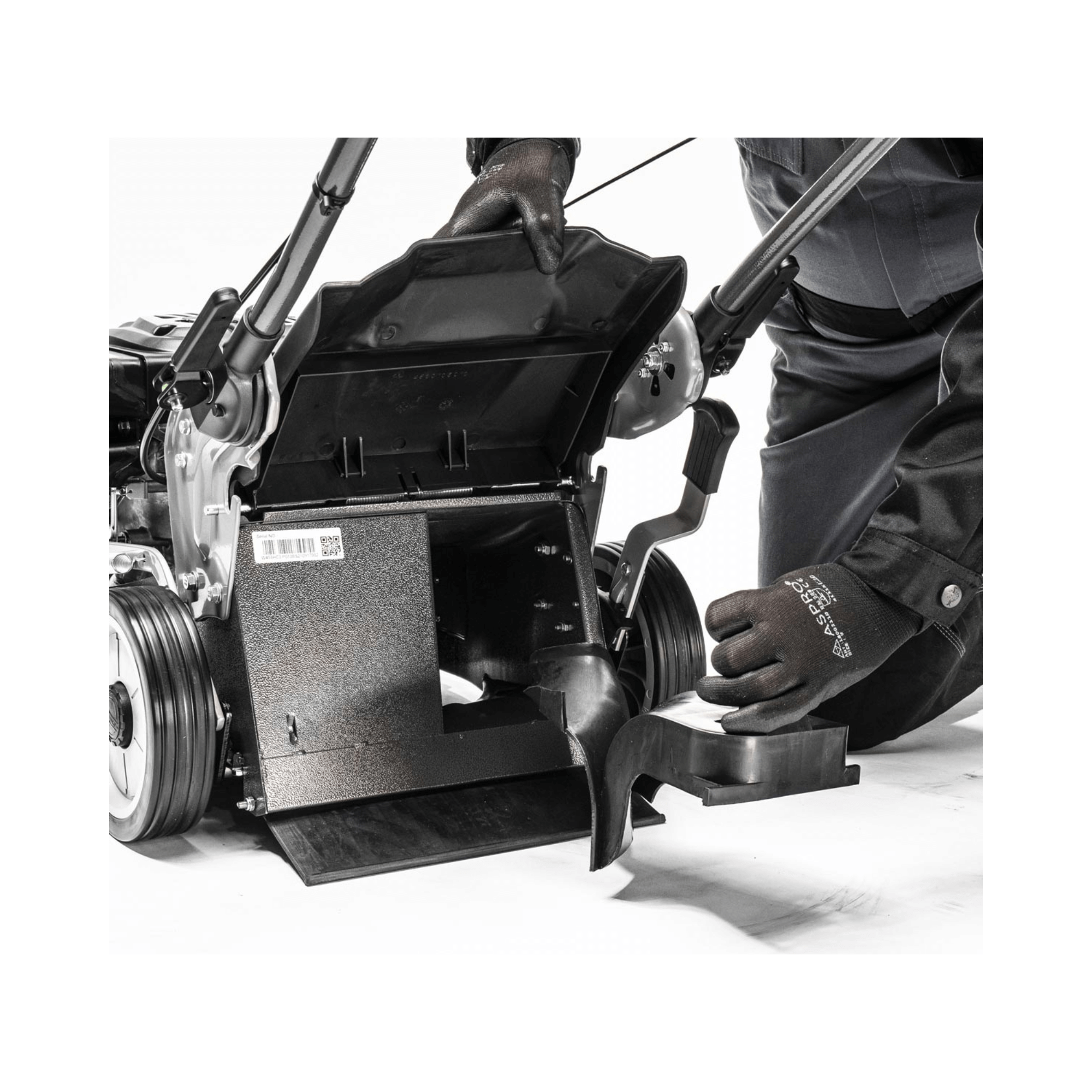 User adjusting the cutting height of the Virtue 46 SVP petrol lawn mower, showcasing its convenient features.