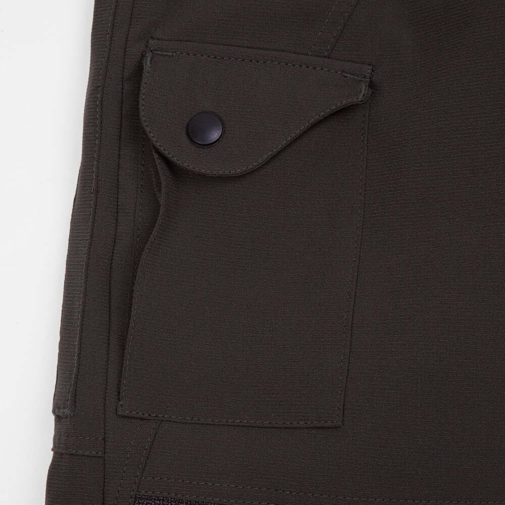 Close-up of olive chainsaw trousers pocket, designed for tree surgeons, highlighting durability and functionality.