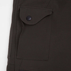 Close-up of olive chainsaw trousers pocket, designed for tree surgeons, highlighting durability and functionality.