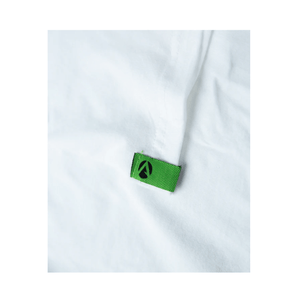 Close-up of the green label on a white short sleeve Arbortec t-shirt for tree surgeons, showcasing quality craftsmanship.