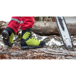 Tree surgeon wearing Haix Protector Ultra 2.0 GTX chainsaw boots on a fallen log next to a chainsaw.