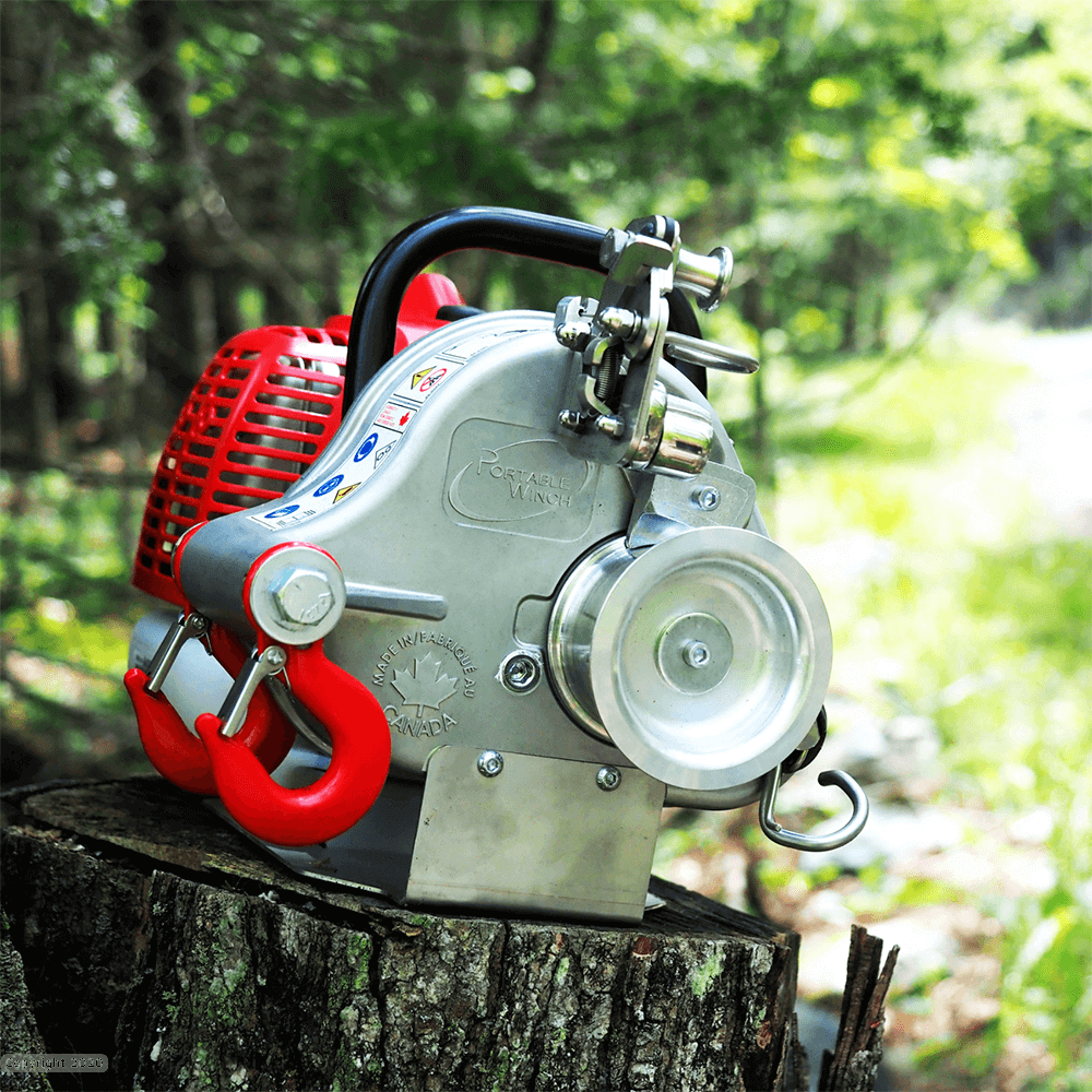 PCW4500 Petrol Pulling Winch on a tree stump, ideal for tree surgeons, showcasing its compact design and powerful engine.