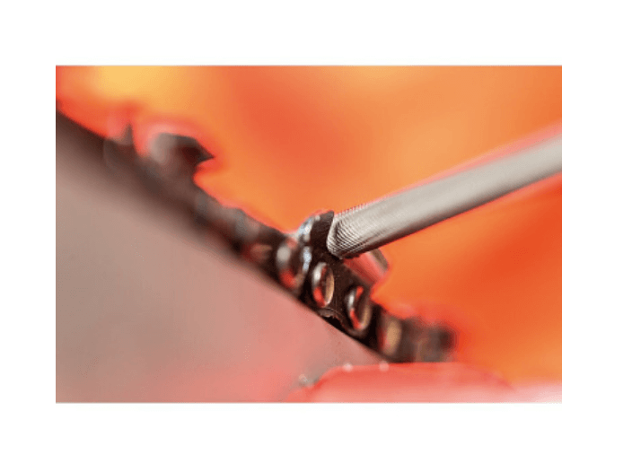 Close-up of a chainsaw file sharpening a saw chain, essential for tree surgeons to maintain cutting efficiency.