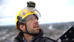A person wearing a Petzl Strato climbing helmet and headlamp, looking upwards while at height, showcasing safety gear for tree surgeons.