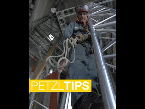 Tree surgeon using PETZL Grillon adjustable lanyard for safe work positioning on a steel structure.