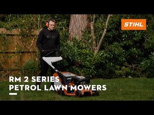 RM 253 T Self Propelled Petrol Lawn Mower being used in a garden by a man wearing headphones.