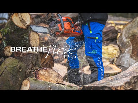 Tree surgeon using Breatheflex Pro Lime chainsaw trousers while cutting logs, showcasing durability and protection.