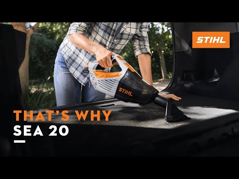 Person using STIHL SEA 20 Cordless Hand Vacuum to clean vehicle interior, showcasing its compact design and powerful performance.