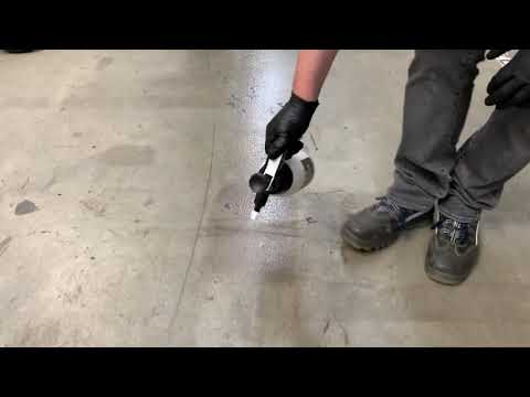 Person using Biological Stain Solution Pro ECO - 1l Sprayer on a stained concrete floor.
