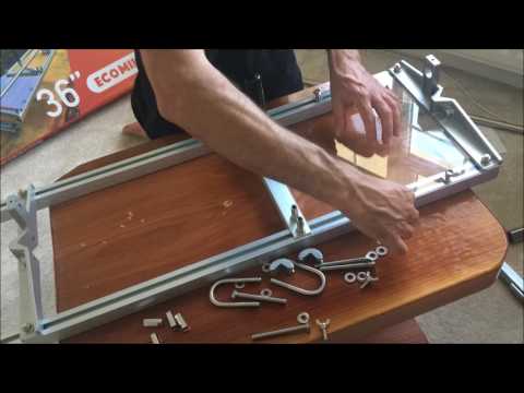 Assembly of a 48" chainsaw mill with tools and parts on a wooden table, ideal for tree surgeons and DIY milling enthusiasts.