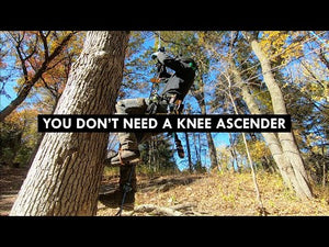 Person using STRYDER Foot Ascender to climb a tree without a knee ascender in a forested area.
