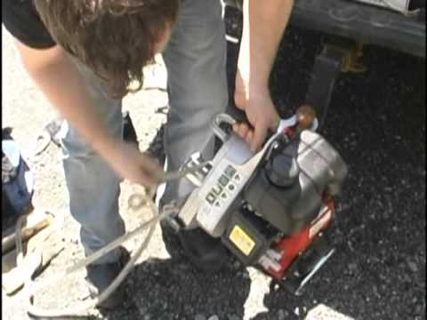 Person using a portable winch with a strap, demonstrating off-road recovery for tree surgeon applications.