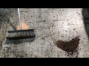 XT 15L Bag Organic Binder being used to absorb spills on a surface with a broom in view.