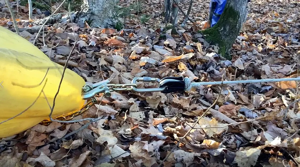 Heavy duty thimble attached to a rope, placed among autumn leaves, used by tree surgeons for strength and safety.