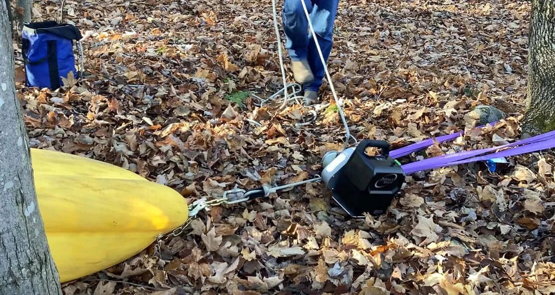 RopeWizer heavy duty thimble in use outdoors, assisting tree surgeon with rope setup in leaf-covered ground.