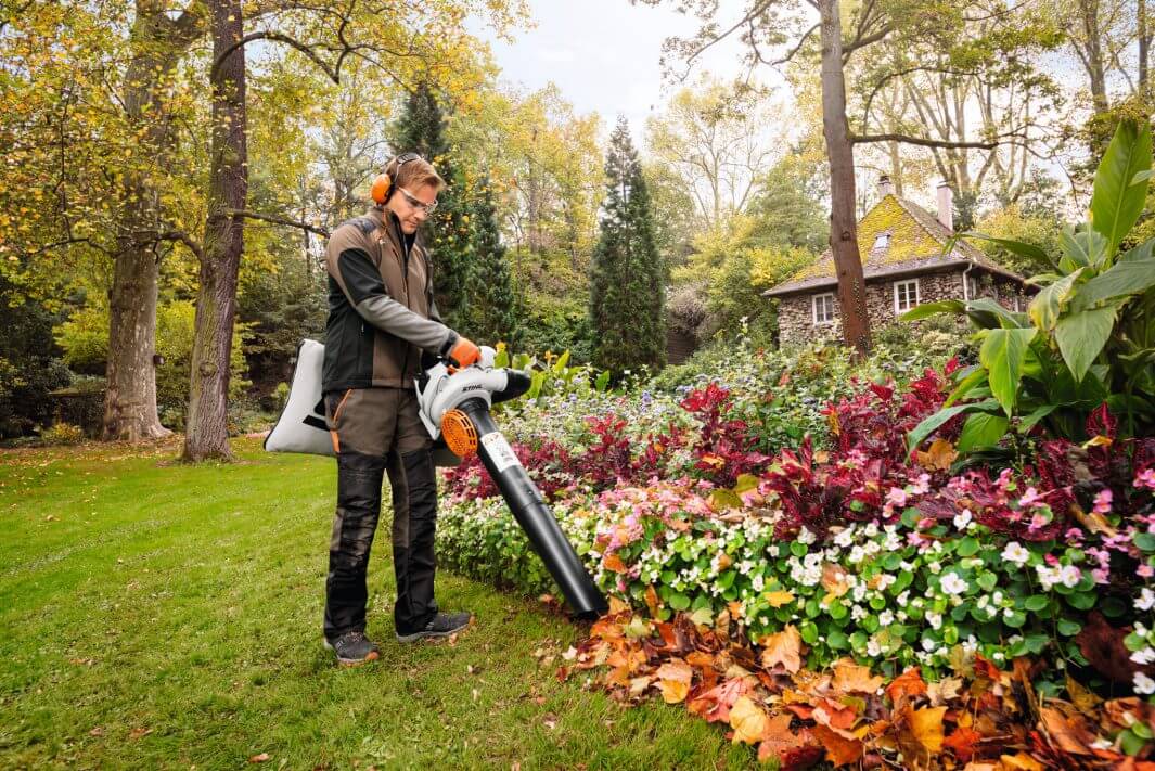 Person using a leaf blower in a garden