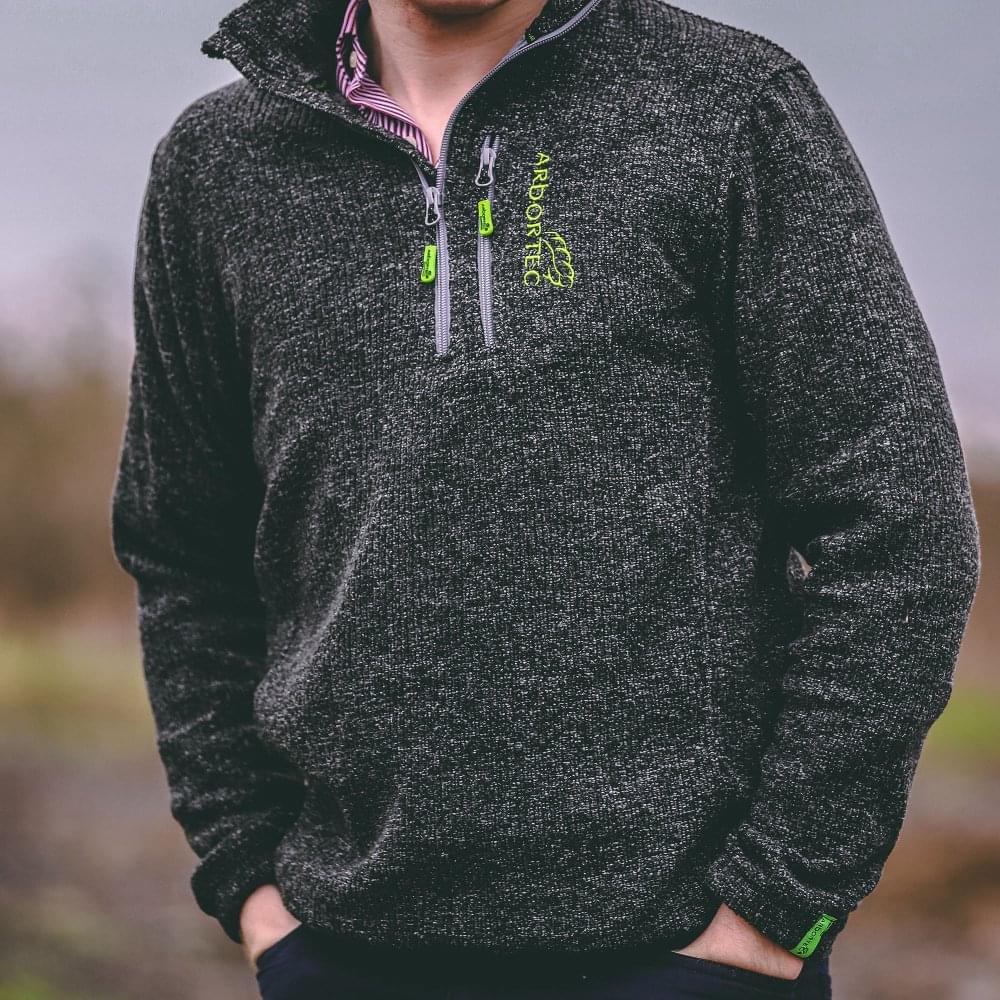 Model wearing Arbortec Wolf Half-Zip Knitted Fleece in grey, ideal for tree surgeons and outdoor activities.